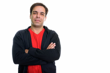 Studio shot of young Persian man with arms crossed isolated agai