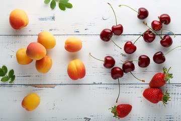 Ripe tasty berries apricot, sweet cherry, strawberry scattered on the table.