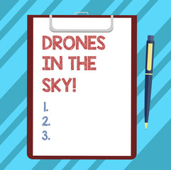 Text sign showing Drones In The Sky. Conceptual photo Aerial helicopter modern device taking pictures and video Blank Sheet of Bond Paper on Clipboard with Click Ballpoint Pen Text Space