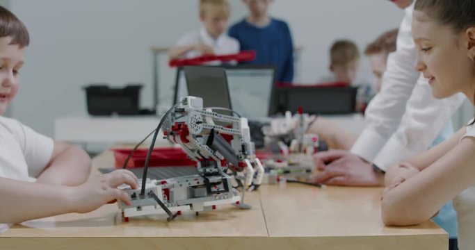 Curious kids working on a functional programable robot during robotics class at school. 4K UHD 60 FPS SLOW MOTION