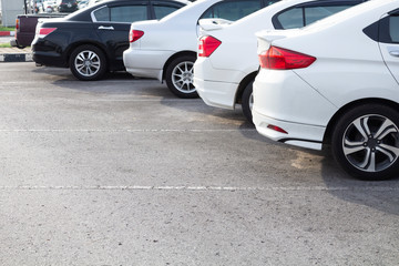 Side view of white car parked in inside outdoor parking lot. Transportation concept.