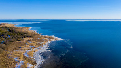 Fototapeta na wymiar Icy shoreline with blue sea