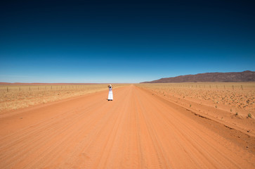 Solitary woman in a namibian road