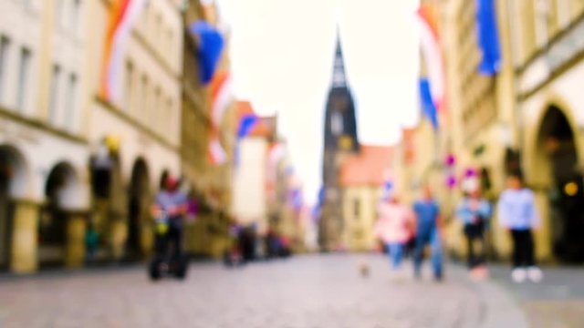 old town muenster, pedestrians, segways, blurred background, &nbsp;EU flags are hanging around the city