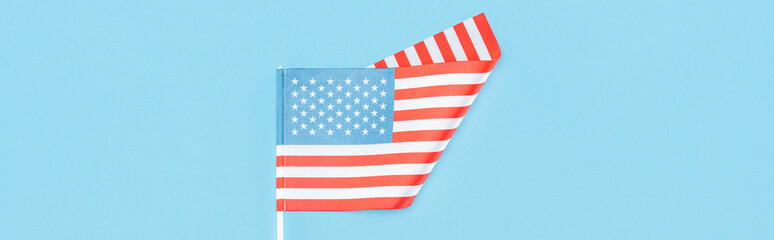 Obraz premium top view of american flag on stick on blue background, panoramic shot