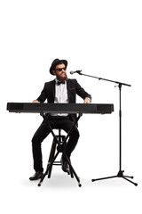 Male musician playing a digital piano and singing on a microphone isolated on white background © Ljupco Smokovski