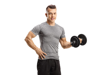 Young man exercising with a dumbbell and looking at the camera