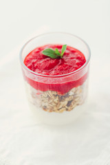 Homemade granola parfait with strawberry jam and mint, yogurt and muesli for healthy breakfast in...