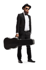 Male musician standing with a guitar case