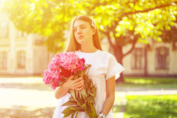 beautiful girl, no makeup, natural beauty, feminism. woman in a white dress, crosswise with a bouquet of peonies