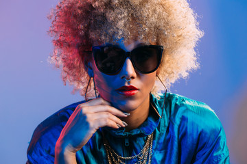 Cool looking young black woman wearing sunglasses in studio setting