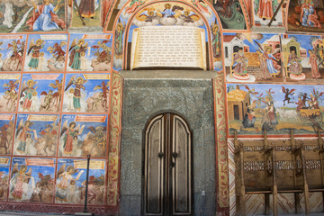 The front door of the church in the Rila monastery, Bulgaria. Religious frescoes on the Bible...
