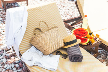 beach stuff bag towel blanket on sun longer. fruits on the table. summer vacation