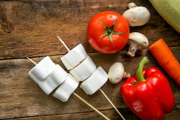 Preparation for barbecue day with friends concept. Vegetables, marshmallow on wooden desk with copy...