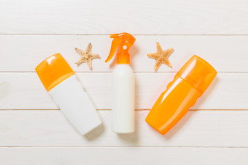 sun protection cream bottles with seashells on white wooden table with copy space. Travel healthcare accessories top view
