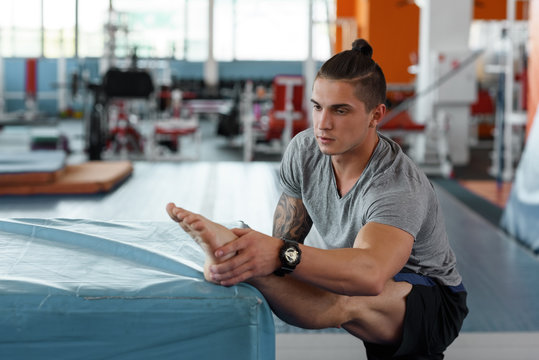 Confident sportsman stretching legs