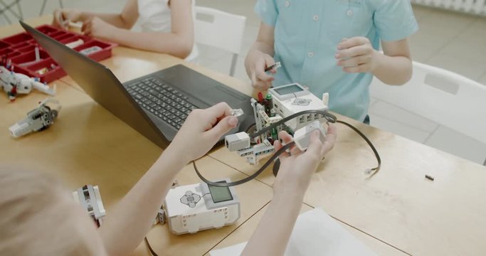 Curious kids working on a functional programable robot during robotics class at school. 4K UHD 60 FPS SLOW MOTION