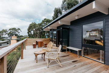 A large deck with outdoor seating at a beach home