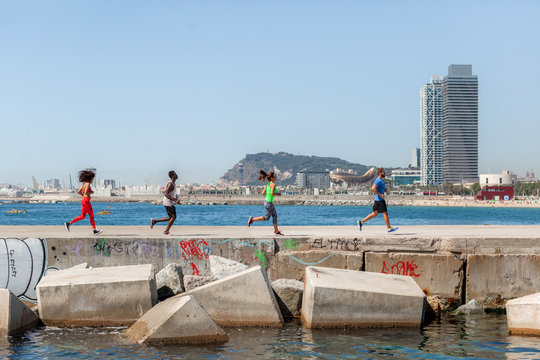 Group of friends running in a dock besides the sea