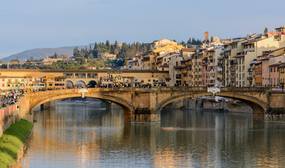 The Ponte Vecchio Bridge is a symbol of the city of Florence. It was built in the XIV century over the river Arno. Evening photo.