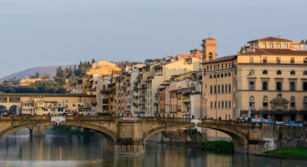 The Ponte Vecchio Bridge is a symbol of the city of Florence. It was built in the XIV century over the river Arno. Evening photo.