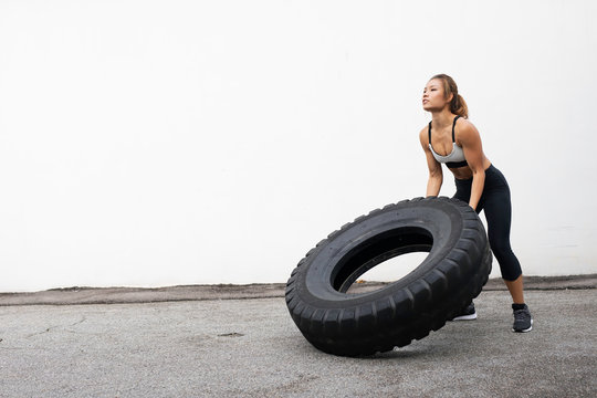 Female Athlete working out with tires