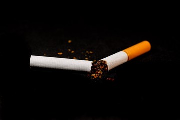 stop smoking concept, a broken cigarette isolated against black, World Tobacco Day
