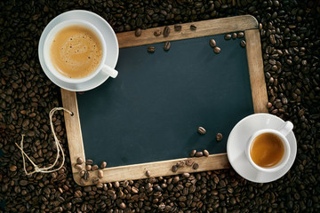 Chalk board or slate with cups of coffee and beans
