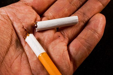 stop smoking concept, a broken cigarette isolated against black, World Tobacco Day