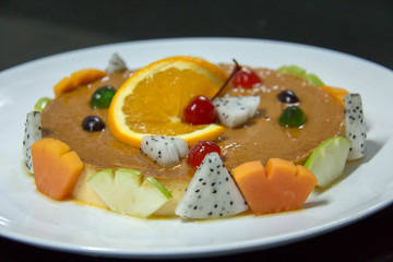 caramel custard with fresh fruit on plate