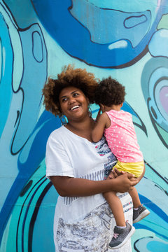 Smiling Black Woman Holding A Baby