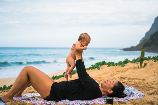 A mother and her newborn baby daughter on the beach