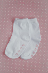 cute white baby socks on a pink background