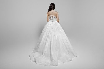 Fototapeta na wymiar Back view of a superbe brunette female model in a white princess wedding dress, isolated on a white background.