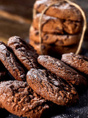 Serving food on slate onto wooden table. Oatmeal cookies biscuit with blueberry on picnic dark tiles countrylike. Chocolate chip cookies tied with string. Serve this dish hot.