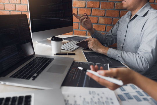 Two software developers are analyzing together about the code written into the program on the computer.