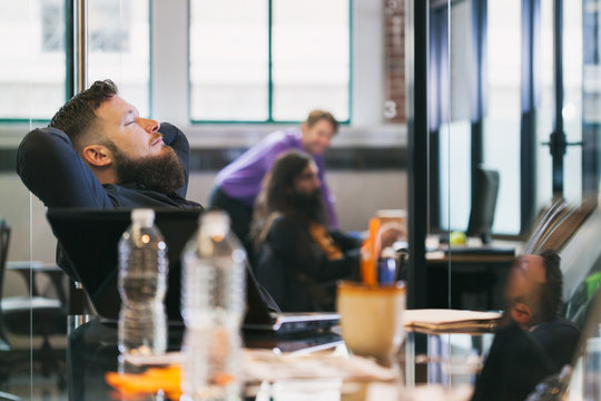 Office: Man Leans Back In Chair After Successful Meeting