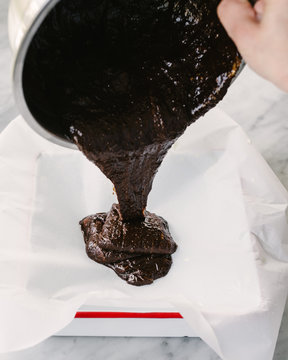 Pouring brownie batter into a pan for baking