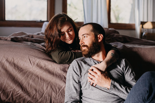Couple Cuddled At Foot Of Bed