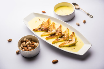 shahi tukra/tukda or Double ka meetha is a bread pudding Indian sweet of fried bread slices soaked in rabid or sweet saffron milk garnished with dry fruits, selective focus