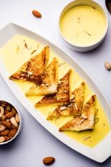 shahi tukra/tukda or Double ka meetha is a bread pudding Indian sweet of fried bread slices soaked in rabid or sweet saffron milk garnished with dry fruits, selective focus