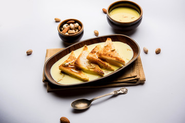 shahi tukra/tukda or Double ka meetha is a bread pudding Indian sweet of fried bread slices soaked in rabid or sweet saffron milk garnished with dry fruits, selective focus