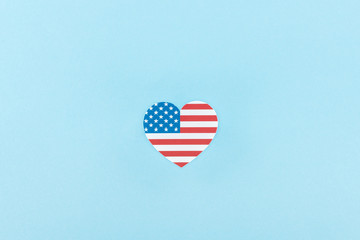 top view of paper cut decorative heart made of american flag on blue background