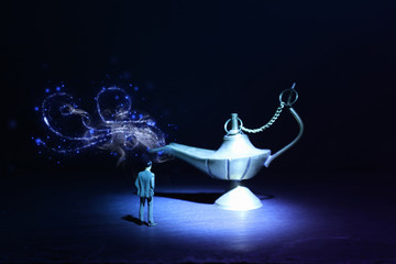 Concept picture of a businessman looking at Aladdin lamp asking for a wish