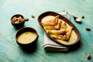 shahi tukra/tukda or Double ka meetha is a bread pudding Indian sweet of fried bread slices soaked in rabid or sweet saffron milk garnished with dry fruits, selective focus