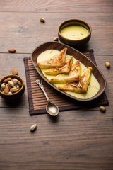 shahi tukra/tukda or Double ka meetha is a bread pudding Indian sweet of fried bread slices soaked in rabid or sweet saffron milk garnished with dry fruits, selective focus