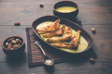 shahi tukra/tukda or Double ka meetha is a bread pudding Indian sweet of fried bread slices soaked in rabid or sweet saffron milk garnished with dry fruits, selective focus