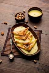 shahi tukra/tukda or Double ka meetha is a bread pudding Indian sweet of fried bread slices soaked in rabid or sweet saffron milk garnished with dry fruits, selective focus