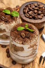 Classic tiramisu dessert in a glass on dark concrete background