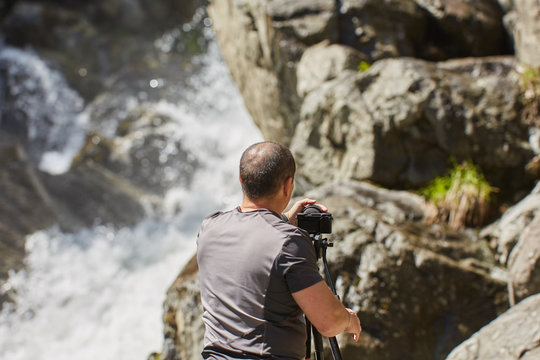 Professional landscape photographer shooting a waterfall